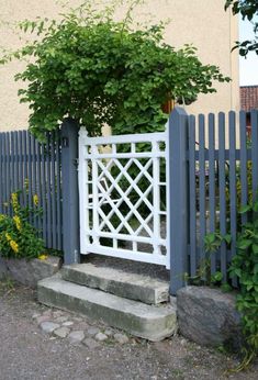 a white gate with a tree growing over it