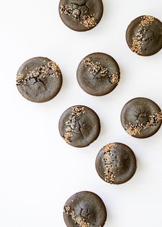 chocolate cookies with gold sprinkles on white surface