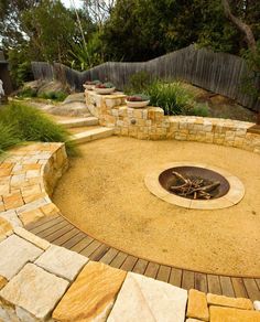 an outdoor fire pit surrounded by stone blocks