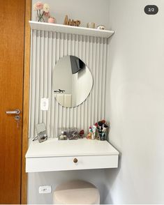 a white vanity with a mirror and stool in front of the door is next to a closet