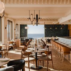 an empty restaurant with tables and chairs overlooking the ocean