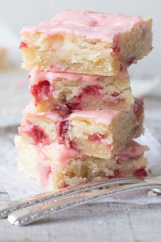 three pieces of strawberry shortcake stacked on top of each other next to a fork