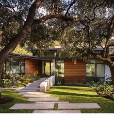 a modern house surrounded by trees and grass