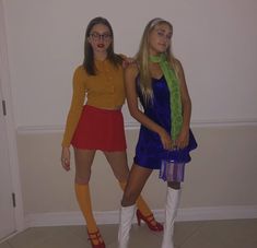 two young women dressed up in costumes and boots