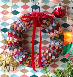 a christmas wreath hanging on the wall with ornaments around it