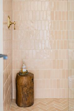 a bathroom with a wooden stool and tiled walls