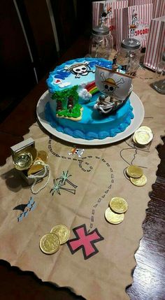 a birthday cake on a table with some gold coins around it and pirate ship in the background