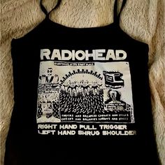 Radiohead Aesthetic Crop Top | Spaghetti Strap Baby Tee | Gothic Grungecore Fashion Show Your Love For Radiohead With This Stylish Band Tee Shirt Crop Top Featuring A Spaghetti Strap Design And Made From Stretchy Spandex, This Baby Tee Combines Comfort And Aesthetic Appeal. Perfect For Fans Of Gothic, Grungecore, Coquette And Punk Styles, This Versatile Top Is Ideal For Layering Or Wearing On Its Own To Showcase Your Unique Fashion Sense. #Radiohead #Bandtee #Croptop #Spaghettistrap #Gothfashion Edgy Summer Tops With Graphic Design, Edgy Graphic Tops For Summer, Edgy Graphic Design Tops For Summer, Edgy Fitted Tops With Graphic Design, Alternative Style Letter Print Tops For Spring, Black Y2k Top With Funny Print, Y2k Graphic Print Tops For Music Festival, Summer Band Merch Top With Graphic Design, Summer Band Merch Tops With Graphic Design