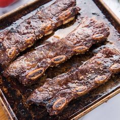 ribs on a baking sheet ready to be cooked in the oven with tomatoes and seasoning