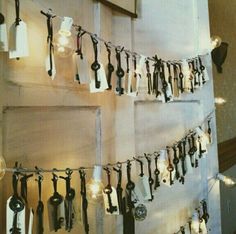 a bunch of lights that are hanging on a wall with some keys attached to it