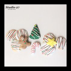 three decorated cookies sitting next to each other on top of a white table with candy canes