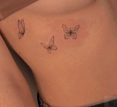 a woman's stomach with three butterflies on it