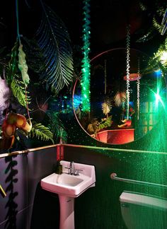 a bathroom decorated in green and purple lights