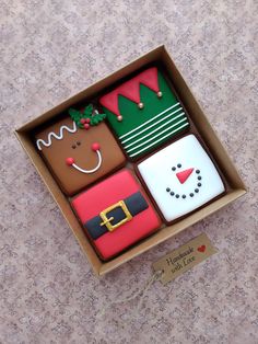 four decorated cookies in a cardboard box