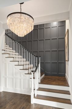 a chandelier hanging from the ceiling in a room with wooden floors and walls