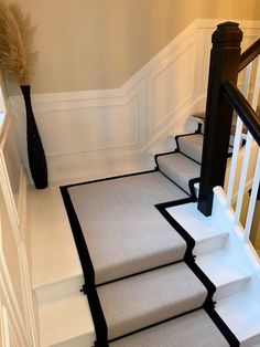 a staircase with carpeted steps and black handrails