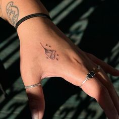 a person's hand with a small tattoo on it