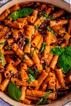 a pan filled with pasta and spinach leaves