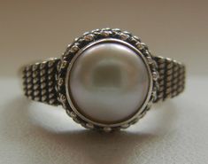 "Bali Suarti sterling silver and pearl ring. Small and beautiful, this ring has a soft iridescent white pearl, set in a raised bezel. The slightly domed pearl is encased in two rows of fine granulation pebbles and two rows of fine braiding. The sides have a striped-pebble vertical design. The back of the setting is solid and the band is thick. Beautifully made in the Balinese tradition and in excellent vintage condition. Please see detailed measurements below. > Size 5.5. *Thank you for doubl Silver Pearl Ring With Cabochon, Elegant Handmade Silver Dome Ring, Sterling Silver Pearl Ring With Pearl Drop, Unique Silver Oval Pearl Ring, Silver Pearl Drop Ring, Silver Pearl Ring With Pearl Drop, Cabochon Pearl Ring In Sterling Silver, Adjustable Pearl Ring For Formal Occasions, Elegant Silver Pearl Ring Stamped 925