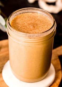 a glass jar filled with liquid sitting on top of a wooden cutting board