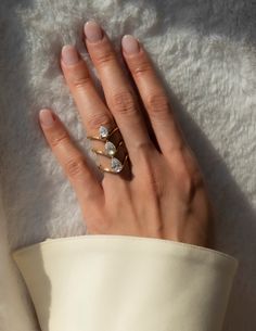 a woman's hand with three rings on it