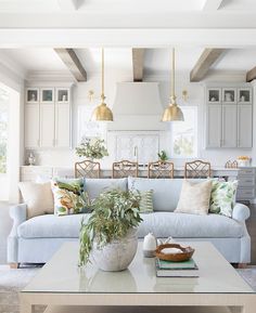 a living room filled with furniture next to a kitchen and dining room table in front of a window