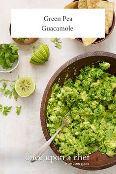 green pea guacamole in a bowl with tortilla chips on the side