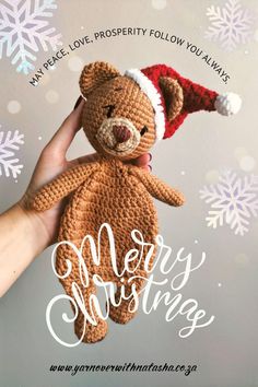 a hand holding a brown teddy bear wearing a santa hat