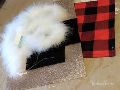 two pieces of fabric with white feathers on top of each other and one piece of black material next to it