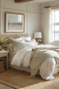 a bed with white linens and pillows in a bedroom next to a large window