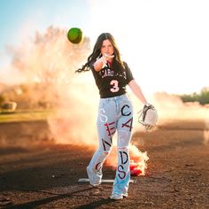 a woman in black shirt and white pants holding a baseball mitt next to a green ball