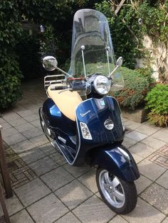 a blue scooter is parked on the sidewalk