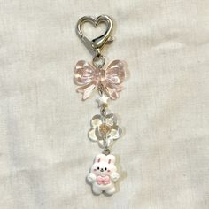 a key chain with a teddy bear and heart charms attached to it's side