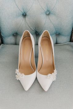 a pair of white shoes sitting on top of a blue chair