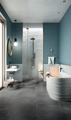 a bathroom with blue walls and flooring, including a large bathtub in the center