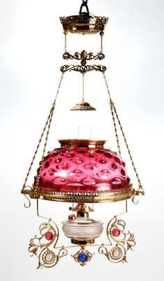 a pink and gold hanging light fixture on a white background