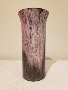 a purple vase sitting on top of a white table