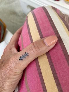 a person's finger with a small tattoo on it