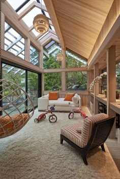 a living room filled with lots of furniture next to a window covered in glass walls