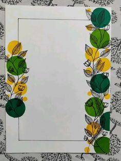 a white paper with green leaves and yellow flowers on the border, in front of a black and white background