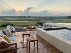 a large hot tub sitting on top of a wooden deck next to a fire pit