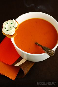 a bowl of tomato soup with cream on top