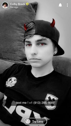 a young man with red eyes wearing a devil hat