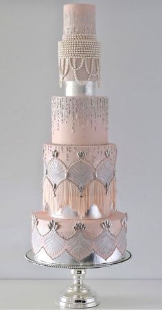 a three tiered wedding cake with beading and pearls on the top is pink