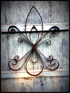 an old metal wall hanging on the side of a building