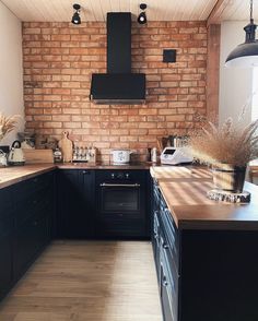 a kitchen with wooden floors and black cabinets