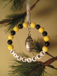 a christmas ornament hanging from a pine tree with beads and footballs on it