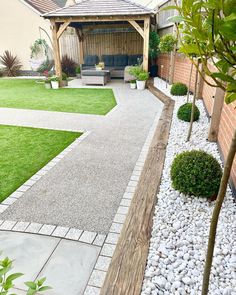 a backyard with grass, gravel and wooden benches in the back yard is well maintained