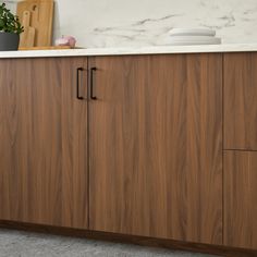 a kitchen with wooden cabinets and white counter tops on top of carpeted flooring