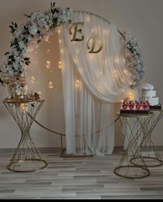 two tables with cakes and cupcakes on them in front of a white backdrop